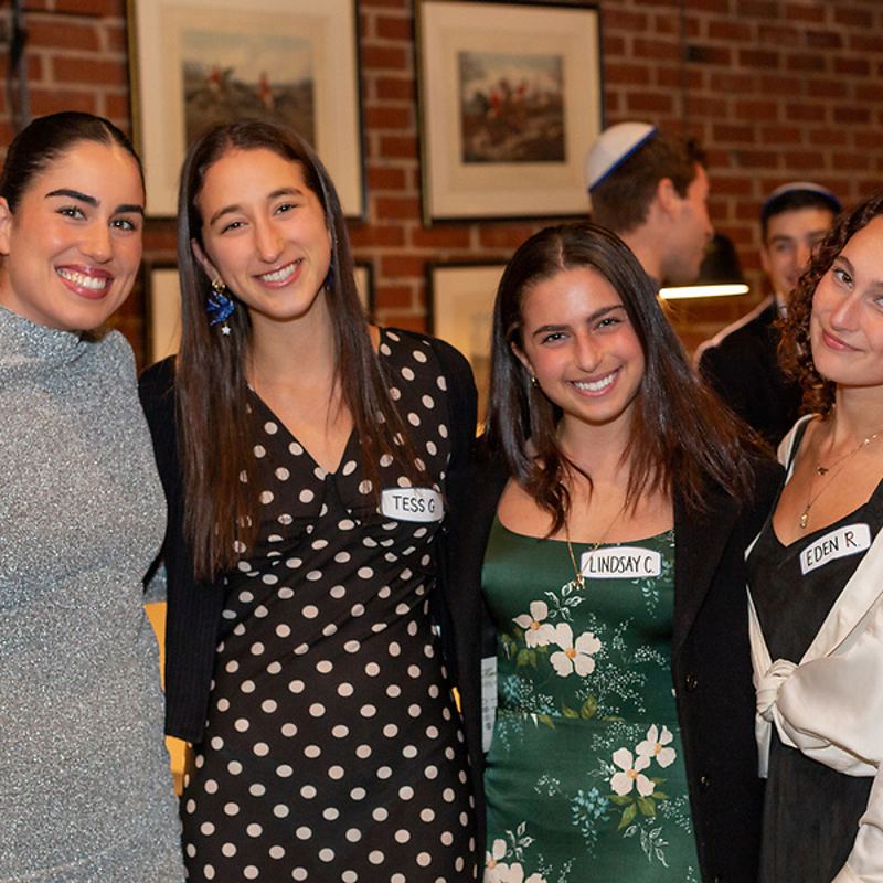 Four friends smiling with name tags at an event