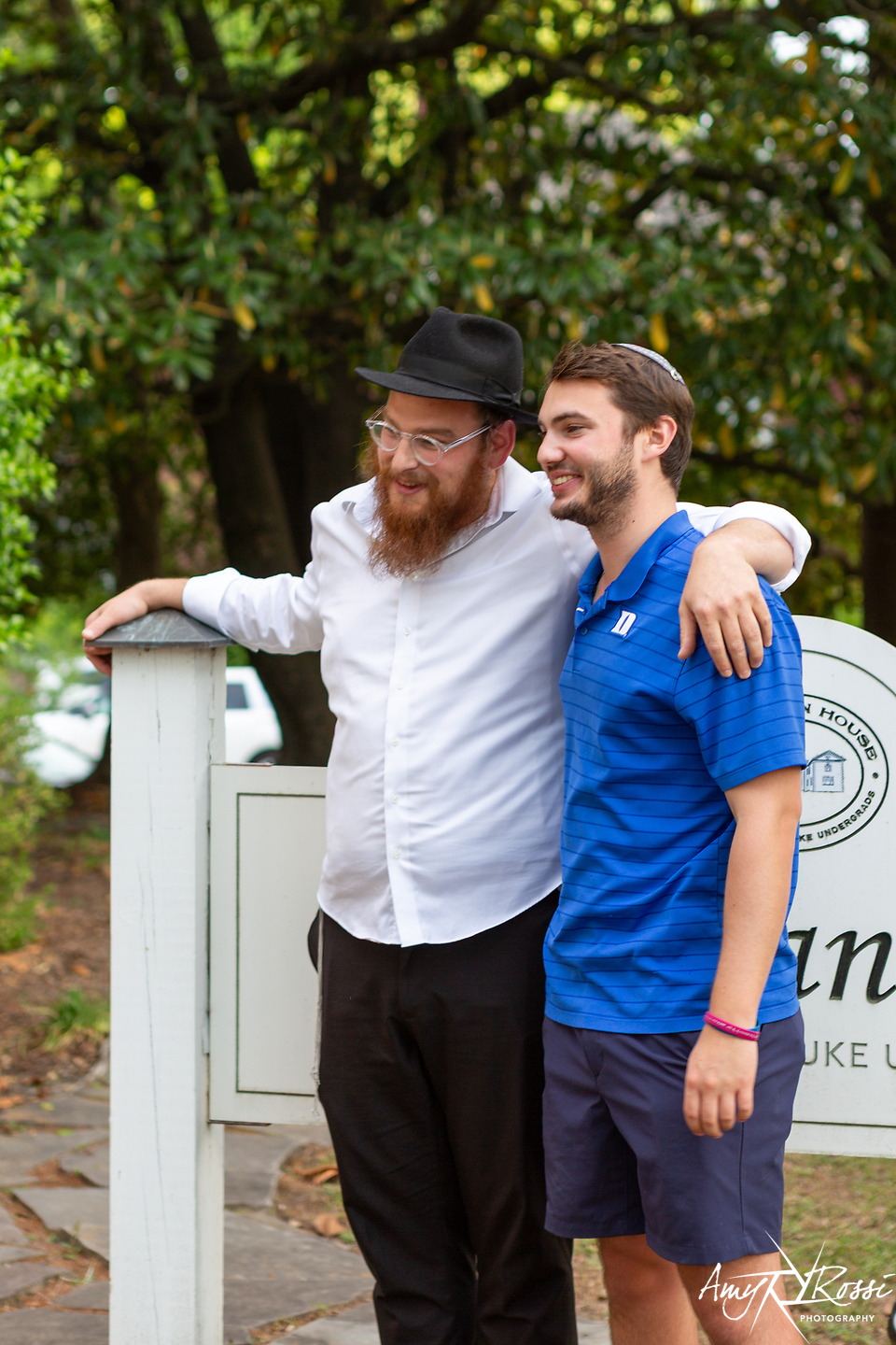 Rabbi Nossen with his arm around a graduating student