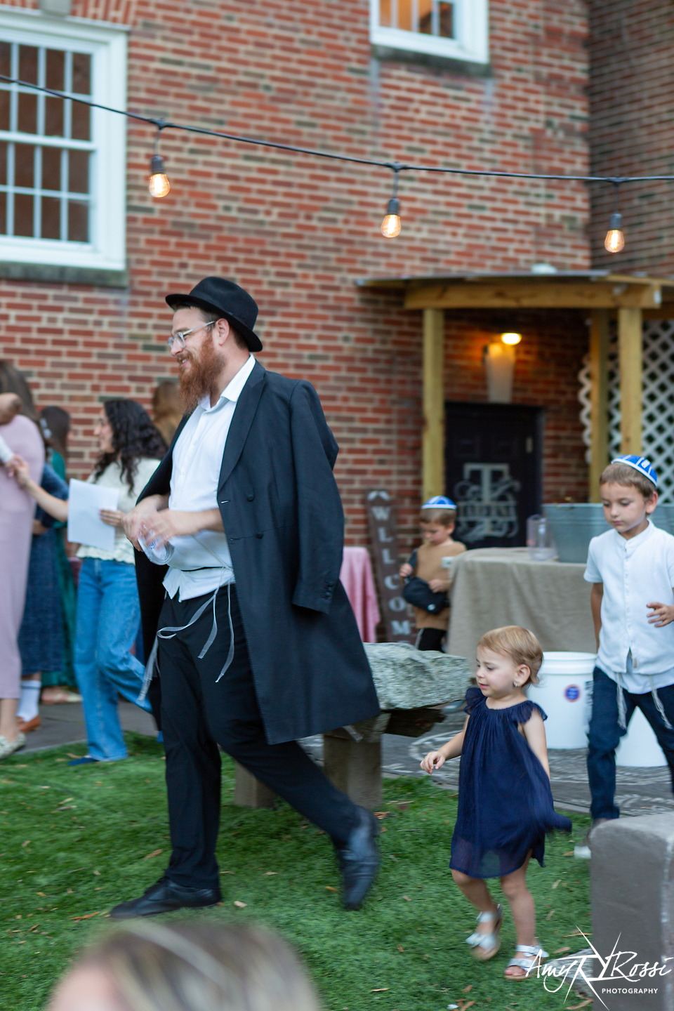 Rabbi Nossen strolling with a toddler through the Shabbat crowd