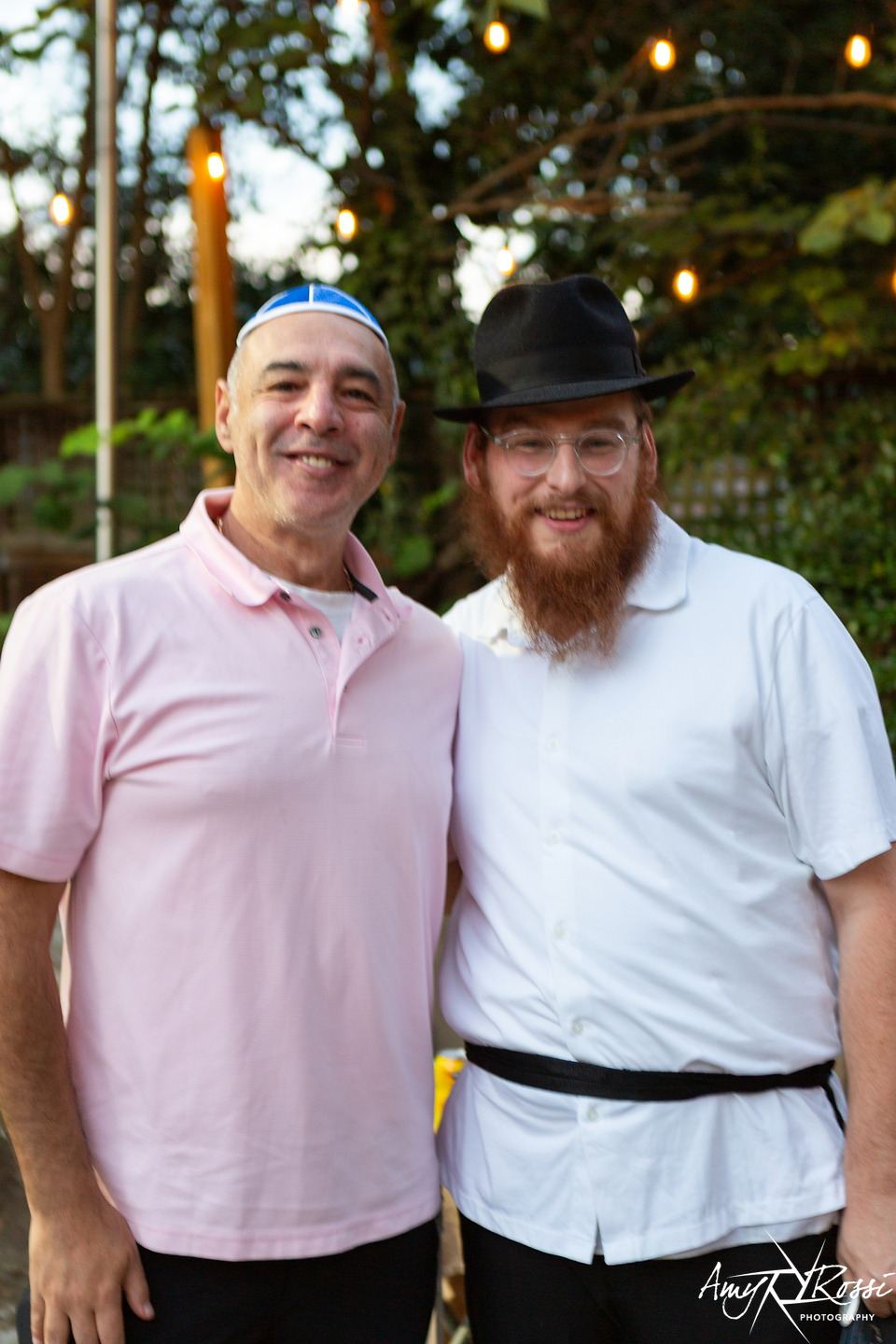 Rabbi Nossen with a visiting parent, both smiling outside the house