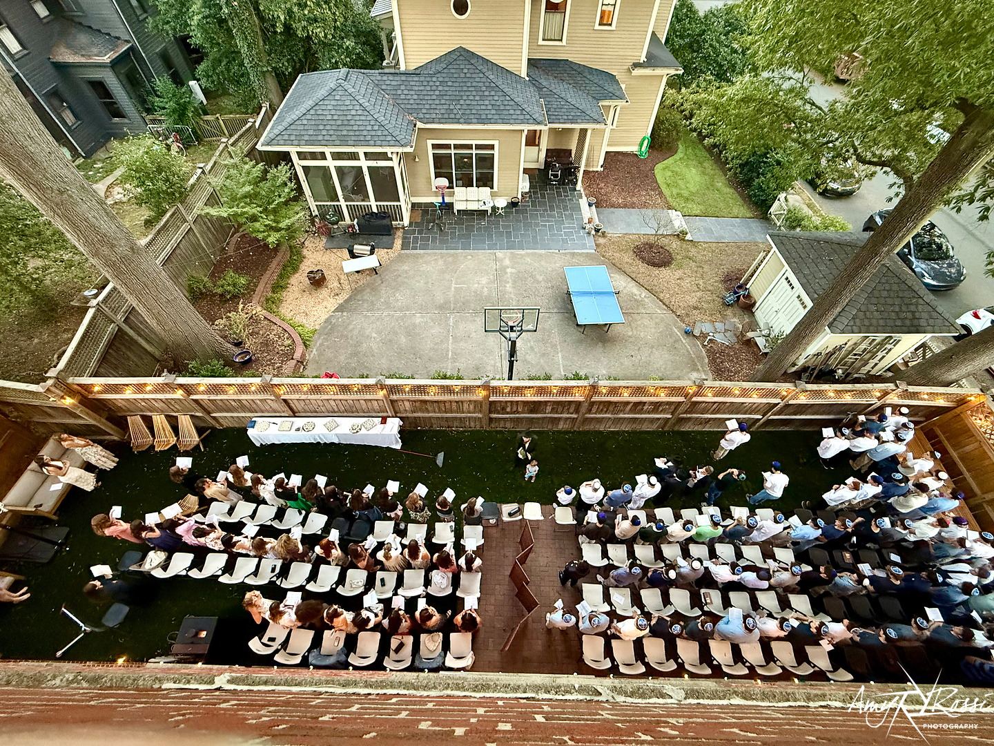 Aerial view of long holiday tables filling the backyard of the Fleishman House