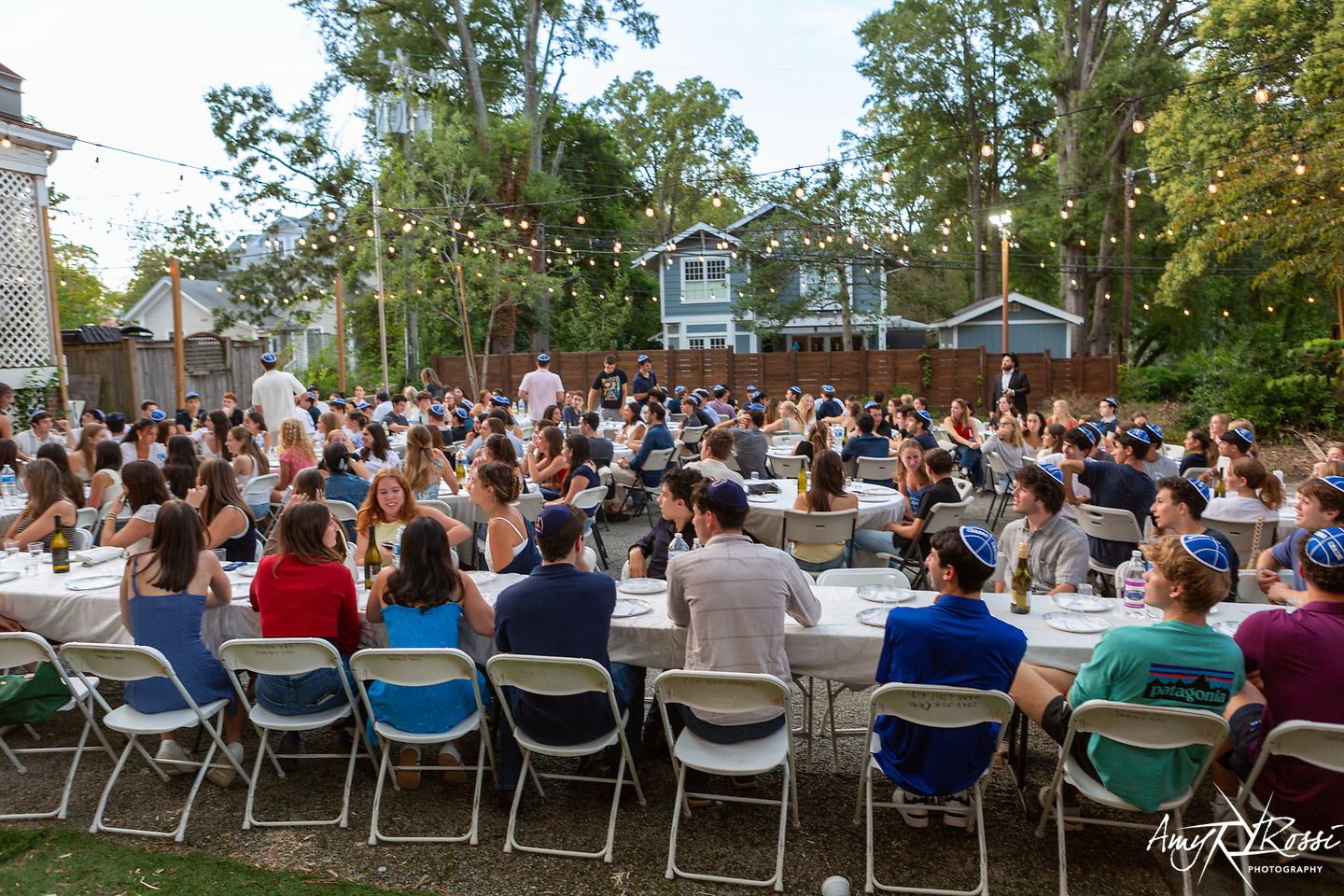 Hundreds of students seated for Shabbat dinner in the Fleishman House backyard